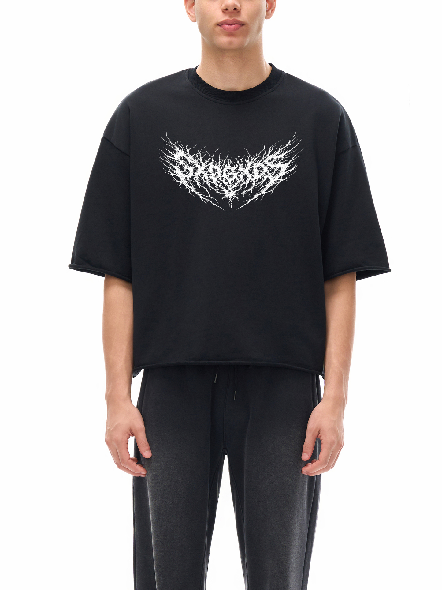 Model wearing black SXDGXDS t-shirt with white heavy metal-style logo across chest.