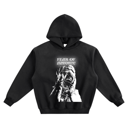 Black hoodie, vintage wash, with "FEAR OF ABANDONMENT" text in distressed font above a monochrome graphic of a distressed person with hands over their face, fingers appearing bound