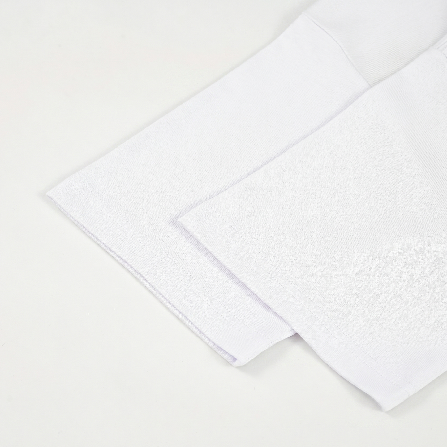 Two white T-shirt sleeves on a light beige background