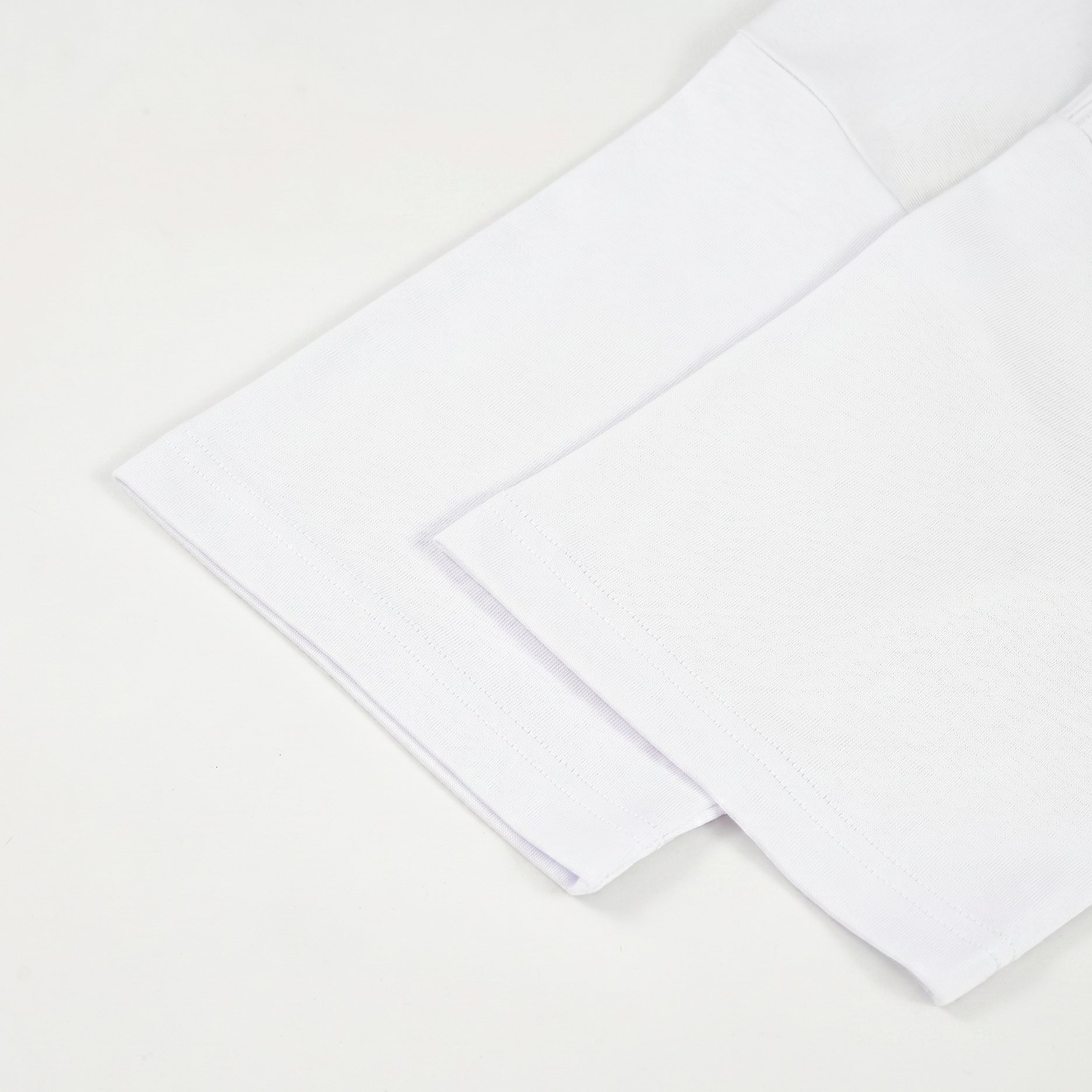 Two white T-shirt sleeves on a light beige background
