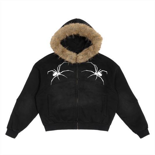 Flat lay of black SXDGXDS zip hoodie featuring tan faux-fur hood and white spiked logo on the chest.