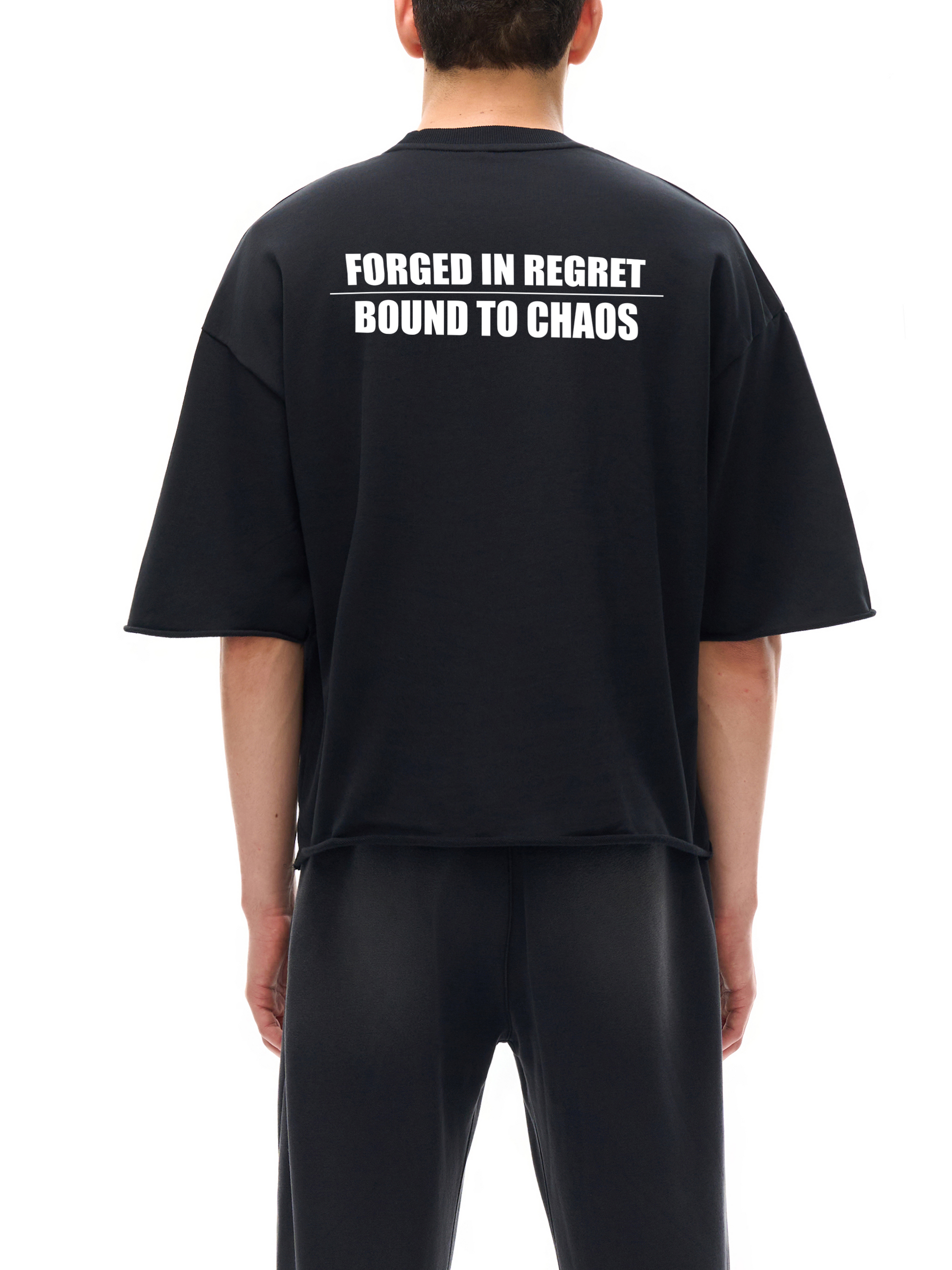 Model wearing black SXDGXDS t-shirt with "Forged in Regret / Bound to Chaos" text on the back