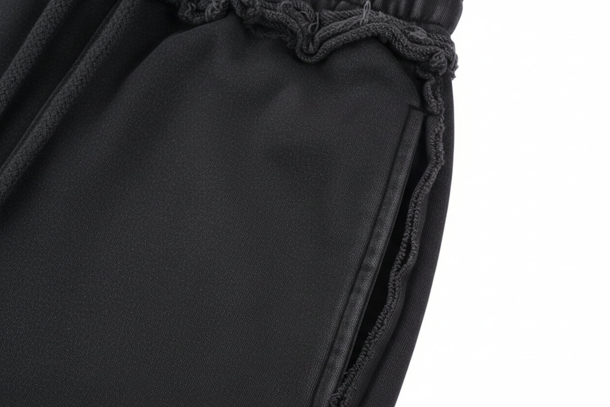Close-up of gray pants with frayed edges on a white background
