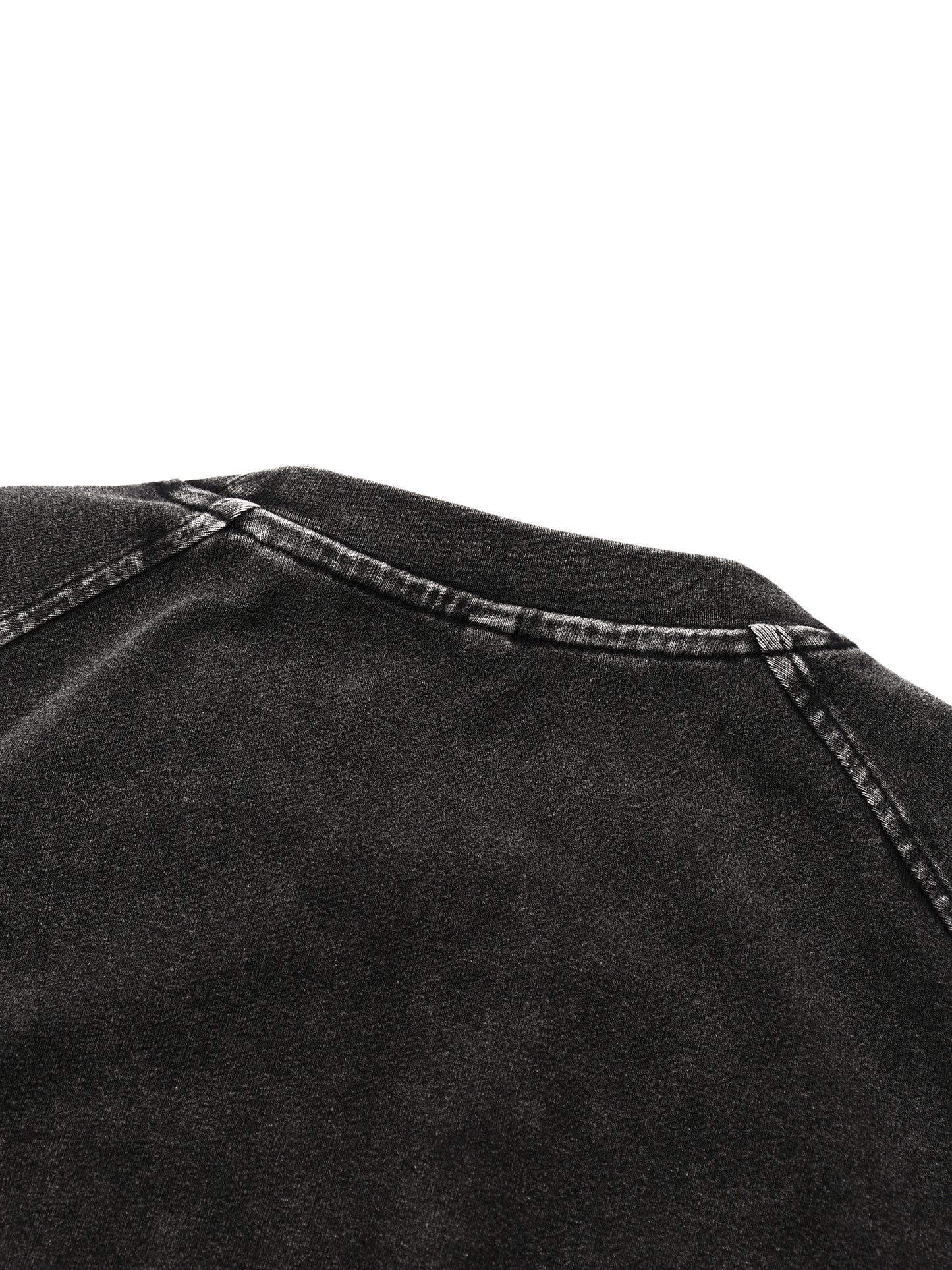 Close-up of black denim fabric with stitching detail on a white background