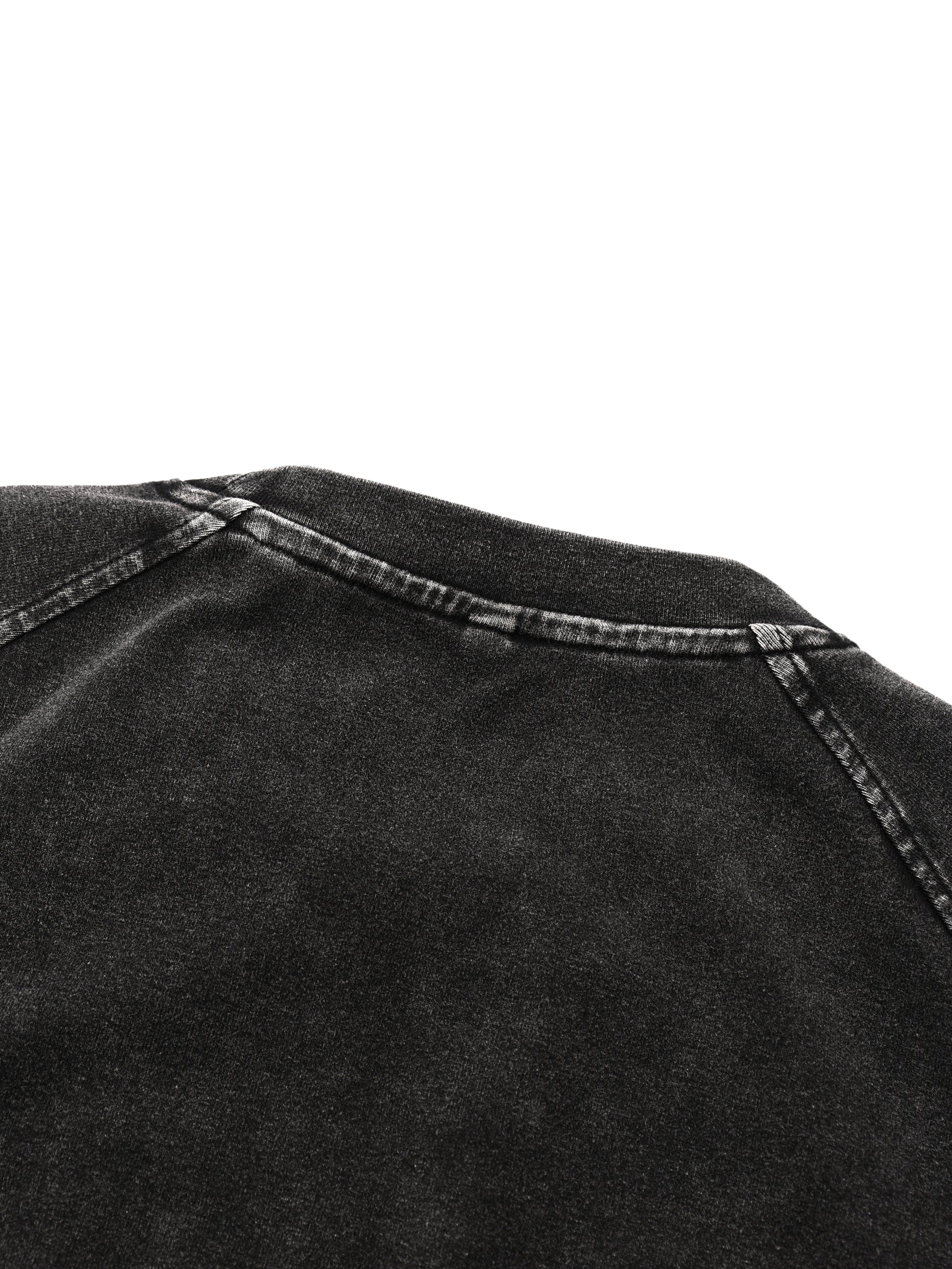 Close-up of black denim fabric with stitching detail on a white background