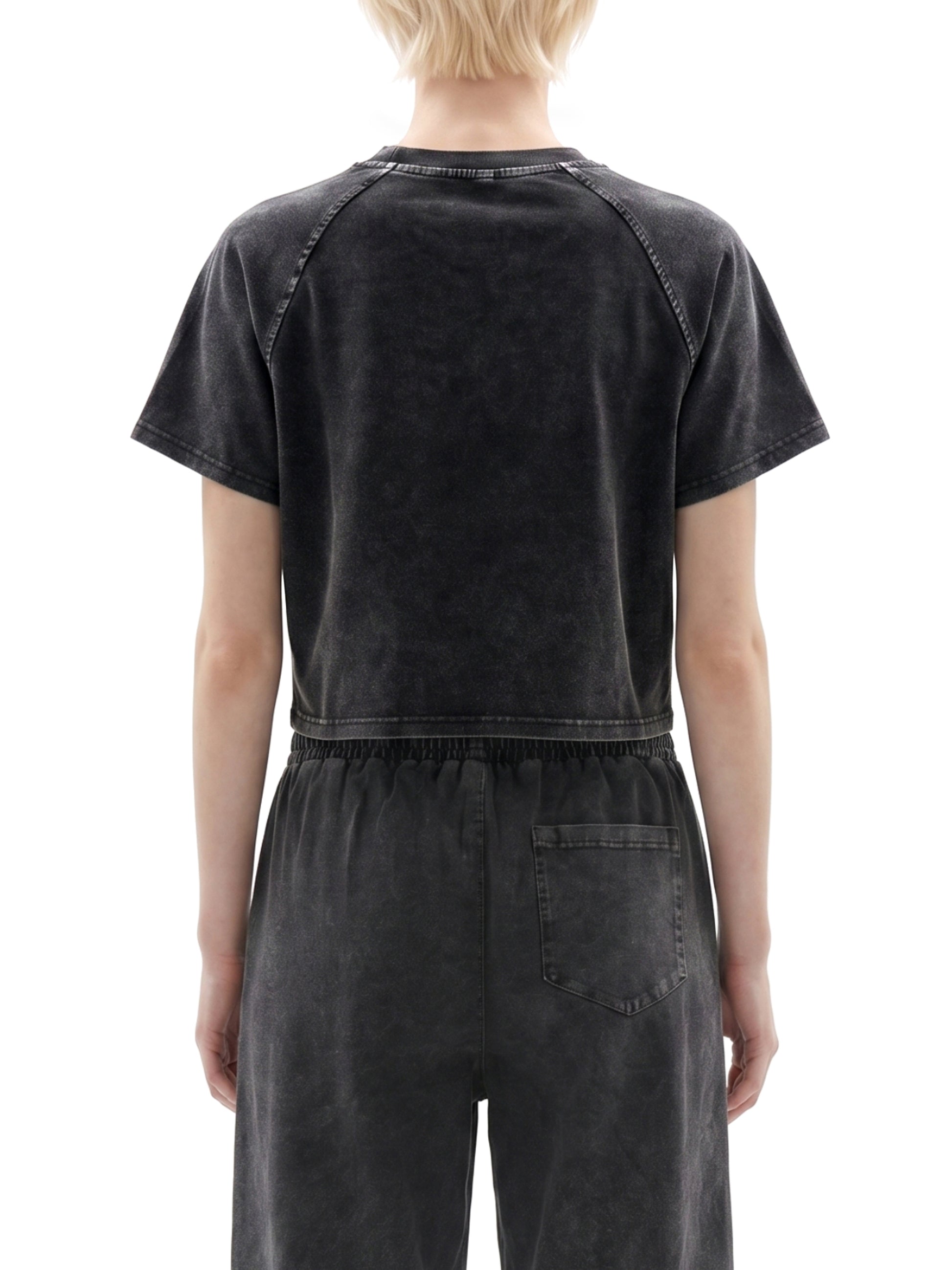 Person wearing a black distressed jumpsuit on a white background